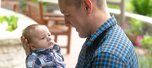 A father smiles at his infant child